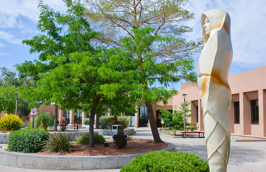 “White Deer of Autumn,” a sculpture by Denny Haskew, stands out among the green landscaping in the outdoor courtyard behind Gurley Hall on The University of New Mexico-Gallup campus on July 18, 2024.