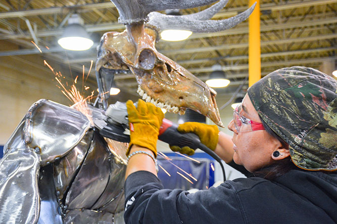 Raquel Martinez puts the finishing touches on her sculpture of an elk centaur inside the welding shop at The University of New Mexico-Gallup on Wednesday, Aug. 7, 2024.