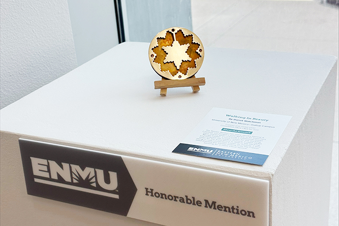Darrel Watchman’s art, a metal brooch entitled “Walking in Beauty,” sits on display at Runnels Gallery at Eastern New Mexico University in Portales, New Mexico, on March 20, 2025.