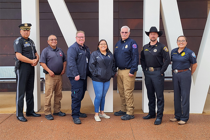 In this Sept. 18, 2024, photo, New Mexico State Police Capt. Shawn Martin, McKinley County Emergency Management Coordinator Doug Watchman, Gallup Fire Department Chief Jon Pairett, McKinley County Metro Dispatch Communications Director Alissa Copi, McKinley County Fire Chief Tim Berry, McKinley County Sheriff James Maiorano III, and Gallup Police Chief Erin Toadlena-Pablo pose for a photo at The University of New Mexico-Gallup.